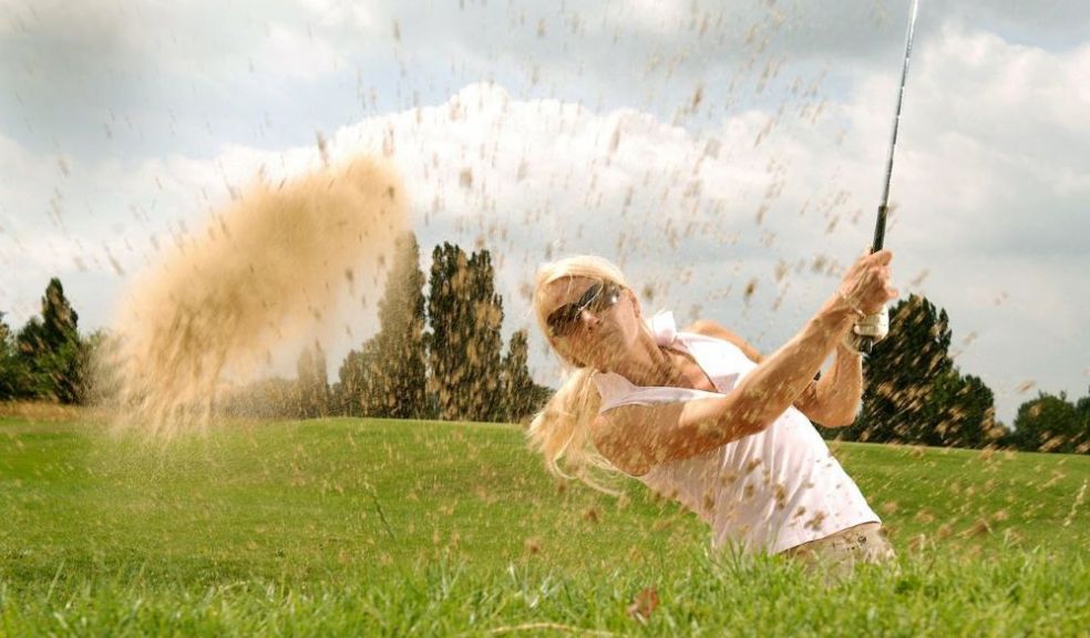 Golfer plays bunker shot